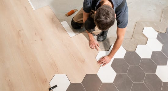 Artisan pose une combinaison parquet et carrelage hexagonal