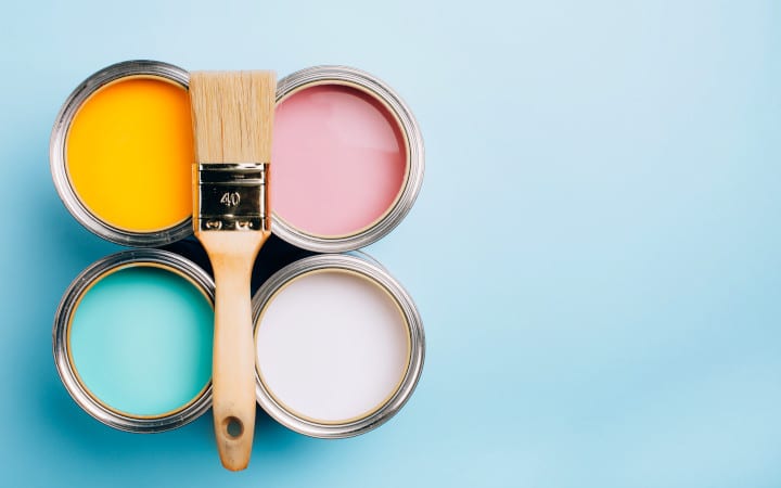 Les meilleurs marques de peintures professionnelles - Pots de peinture ouverts orange, blanc, rose et turquoise avec un pinceau