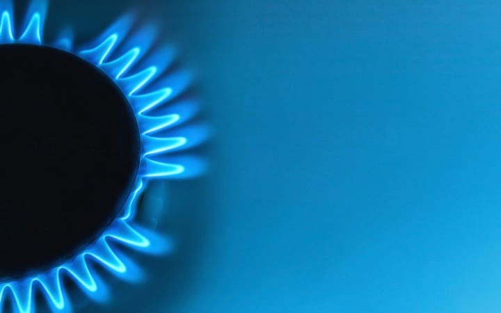 Flamme bleue de gaz naturel sur fond bleu