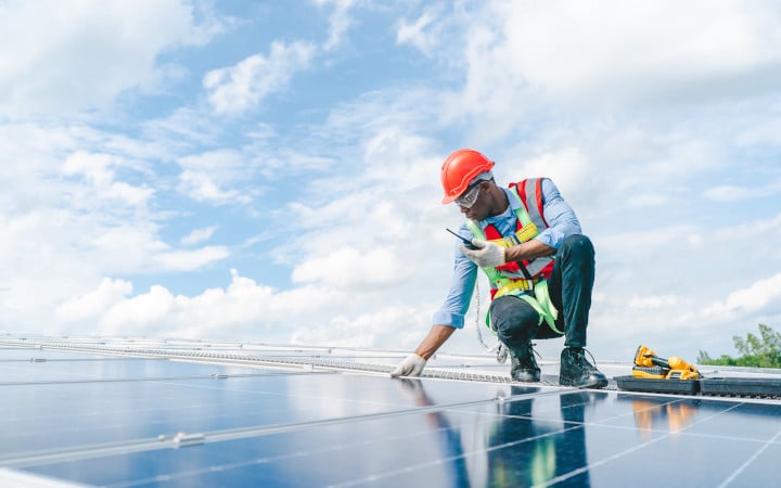 Ingénieurs vérifiant l’installation de panneaux solaires sur le toit d’une maison individuelle