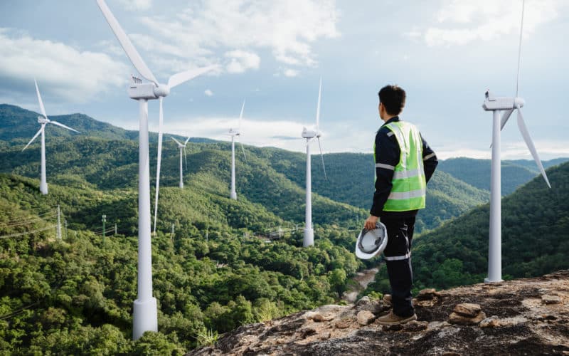 Jeune ingénieur de maintenance travaillant dans un parc éolien d'énergie renouvelable