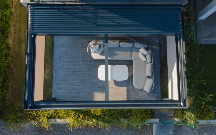 Vue du dessus d'une pergola bioclimatique à lame orientable et rétractable résistant aux vents forts