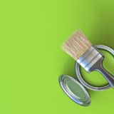 Pinceau et pot de peinture verte représentant une peinture écologique