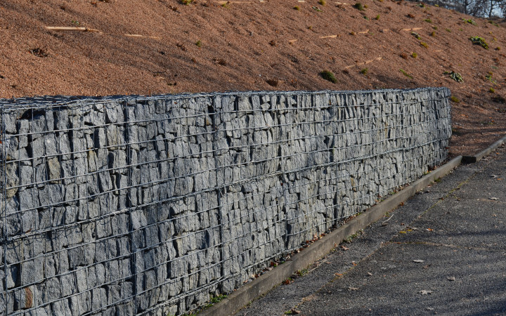 Pose d'un gabion sur un terrain en pente pour faire office de mur de soutènement