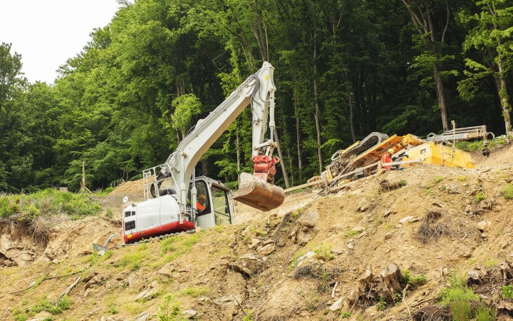 Terrassement d'un terrain en pente à l'aide d'un tractopelle