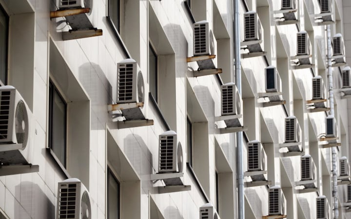 Unités extérieures de climatisation installé sur la façade d'un immeuble en copropriété